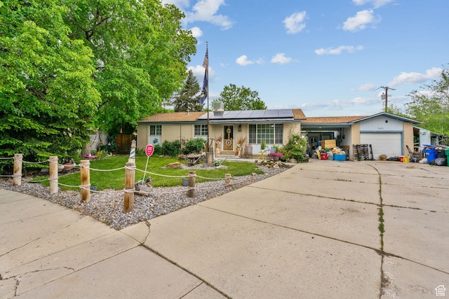 7472 S Silver Cir, West Jordan, UT 84084 - single story home with an attached garage, brick siding, driveway, roof mounted solar panels, and a front yard