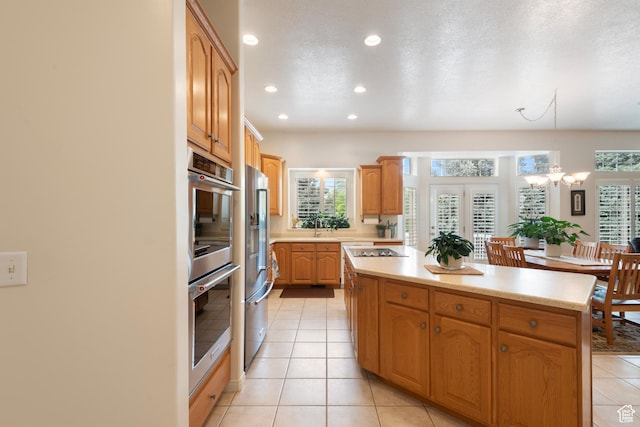 kitchen featuring stainless steel appliances, a kitchen island, recessed lighting, light countertops, and a chandelier