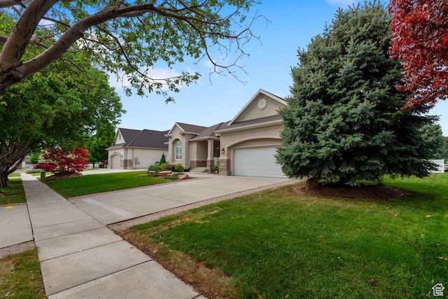 view of front of house with stucco siding, driveway, a front yard, and an attached garage