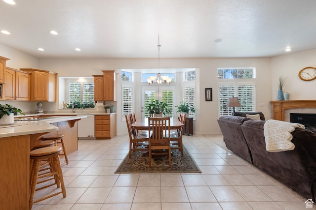 dining room featuring a chandelier, light tile patterned floors, recessed lighting, and a tile fireplace