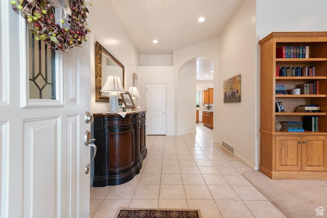 foyer entrance with arched walkways, light tile patterned floors, recessed lighting, and baseboards