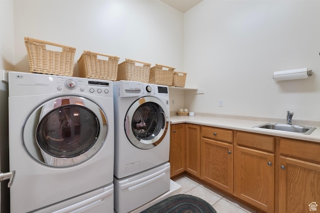 clothes washing area with independent washer and dryer, light tile patterned floors, and cabinet space