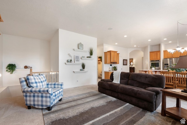living room featuring carpet floors, arched walkways, a chandelier, and recessed lighting