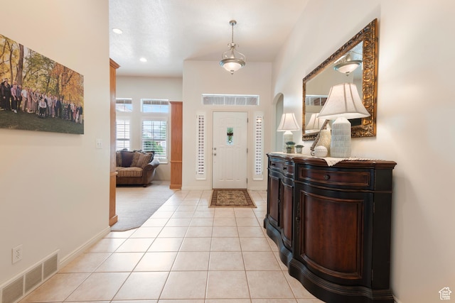 foyer featuring light tile patterned floors, baseboards, and recessed lighting