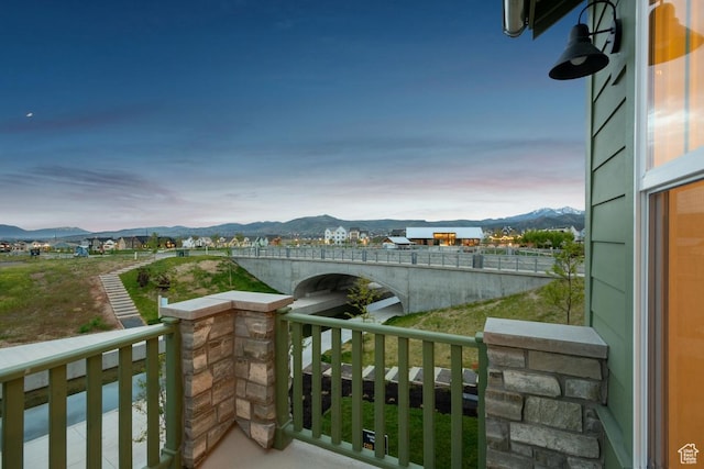balcony at dusk featuring a mountain view