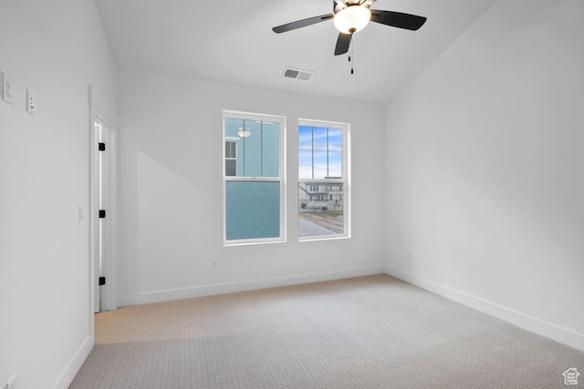 carpeted spare room featuring a ceiling fan, baseboards, and lofted ceiling