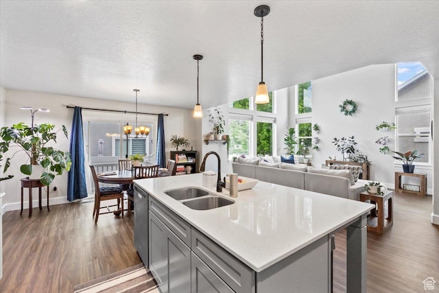 kitchen featuring a sink, gray cabinets, dark wood-type flooring, and dishwasher