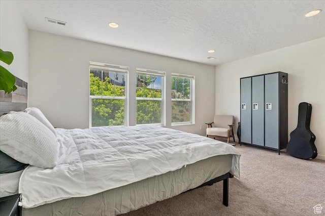 bedroom with carpet flooring, recessed lighting, and a textured ceiling