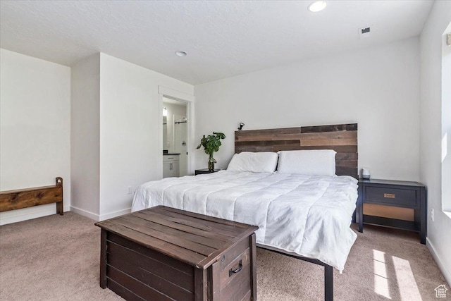 bedroom featuring light colored carpet, recessed lighting, baseboards, and connected bathroom