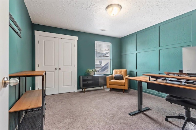 office space with carpet flooring and a textured ceiling