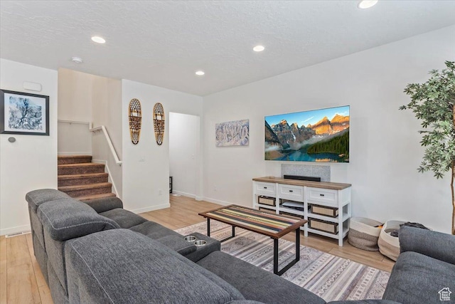 living room featuring light wood-type flooring, stairs, recessed lighting, and baseboards