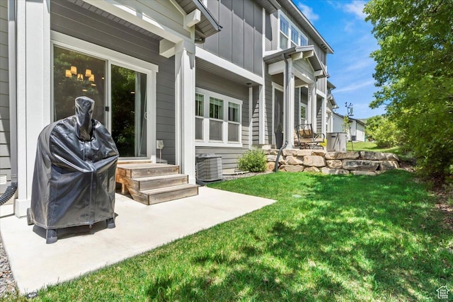 view of grassy yard with entry steps, a patio area, and central AC