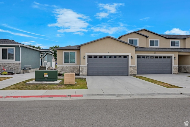 200 W 1200 S Unit 18, Tremonton, UT 84337 - view of front of home with stone siding, stucco siding, driveway, and an attached garage