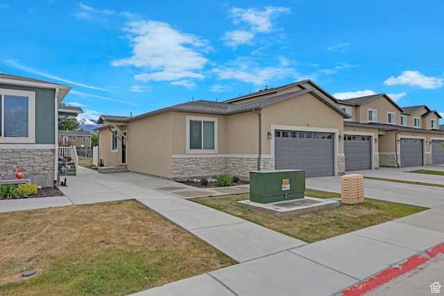200 W 1200 S Unit 18, Tremonton, UT 84337 - view of front facade featuring stone siding, stucco siding, an attached garage, driveway, and a front lawn