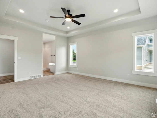 1016 W Mountain Orchard Dr, Pleasant View, UT 84414 - unfurnished bedroom with a tray ceiling, light colored carpet, baseboards, recessed lighting, and ensuite bathroom