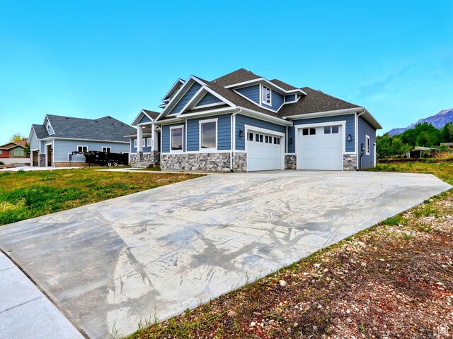 1016 W Mountain Orchard Dr, Pleasant View, UT 84414 - craftsman-style home with stone siding, a garage, driveway, and a mountain view