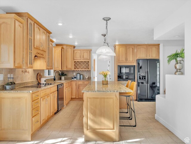 3351 E Deer Hollow Cir S, Sandy, UT 84092 - kitchen with black appliances, light brown cabinetry, a kitchen island, light stone counters, and stone tile floors