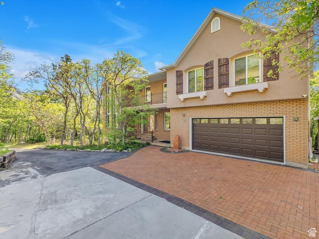 3351 E Deer Hollow Cir S, Sandy, UT 84092 - view of front facade with decorative driveway, brick siding, an attached garage, and stucco siding