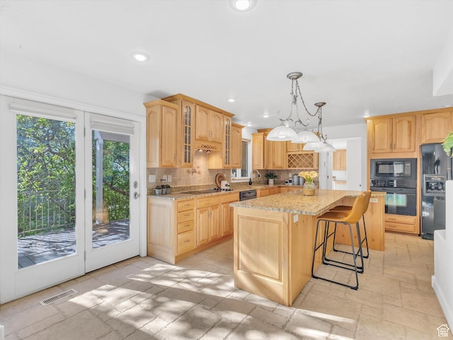 3351 E Deer Hollow Cir S, Sandy, UT 84092 - kitchen featuring black appliances, decorative backsplash, a center island, stone tile floors, and glass insert cabinets