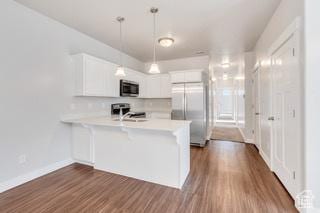 303 W 435 N, Vineyard, UT 84059 - kitchen featuring appliances with stainless steel finishes, a peninsula, light countertops, white cabinetry, and dark wood-style floors