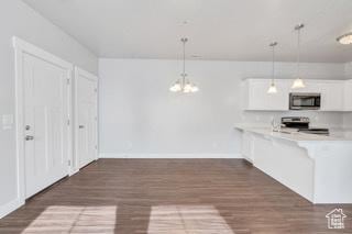 303 W 435 N, Vineyard, UT 84059 - kitchen with appliances with stainless steel finishes, white cabinetry, a chandelier, light countertops, and dark wood-type flooring