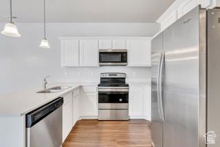 303 W 435 N, Vineyard, UT 84059 - kitchen featuring stainless steel appliances, a sink, light countertops, a peninsula, and white cabinets