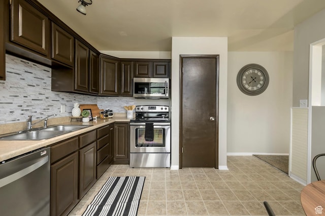 7648 S 2290 W, West Jordan, UT 84084 - kitchen featuring appliances with stainless steel finishes, a sink, dark brown cabinetry, and backsplash