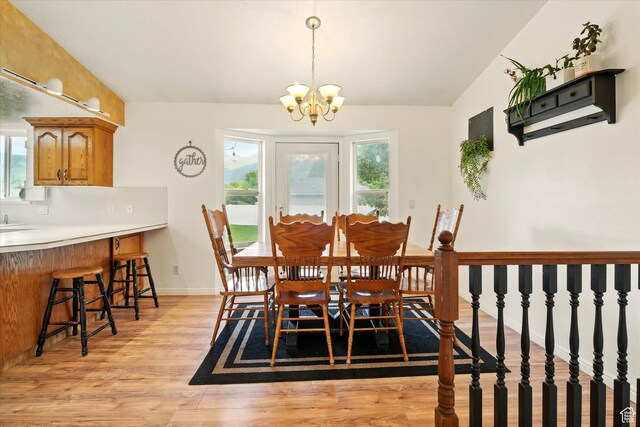 211 S 300 E, Wellsville, UT 84339 - dining room featuring light wood finished floors, a chandelier, baseboards, and vaulted ceiling