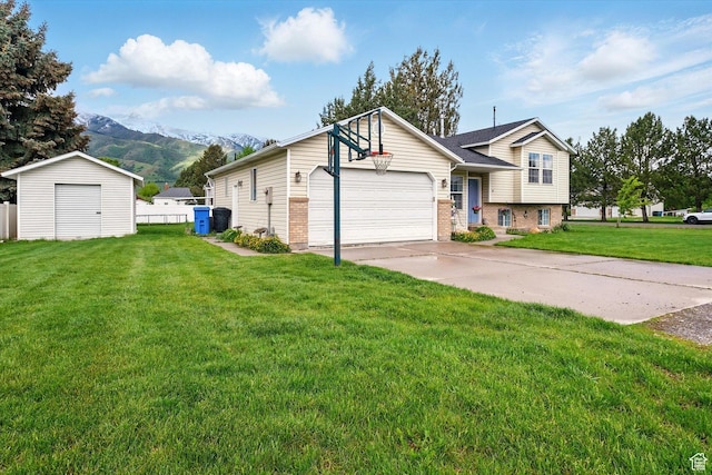 211 S 300 E, Wellsville, UT 84339 - view of front of home featuring a mountain view, brick siding, a storage unit, concrete driveway, and an outbuilding