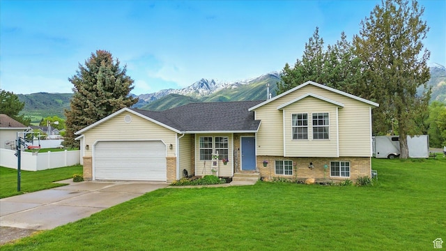211 S 300 E, Wellsville, UT 84339 - split level home featuring a mountain view, an attached garage, concrete driveway, and brick siding