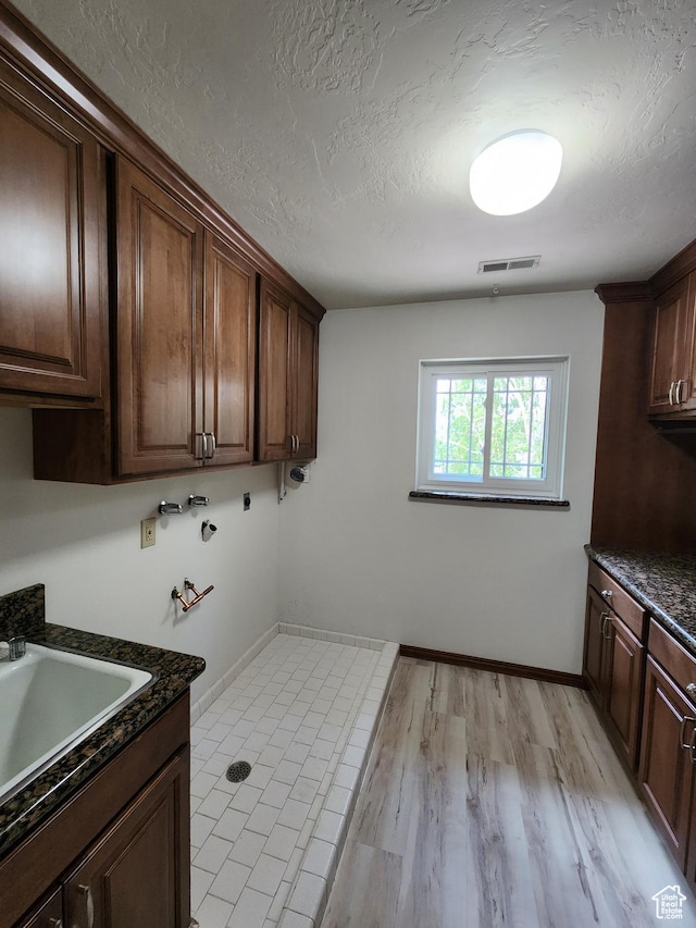 11258 S Brandon Park Dr E, Sandy, UT 84092 - laundry area featuring cabinet space, washer hookup, a textured ceiling, baseboards, and light wood-type flooring