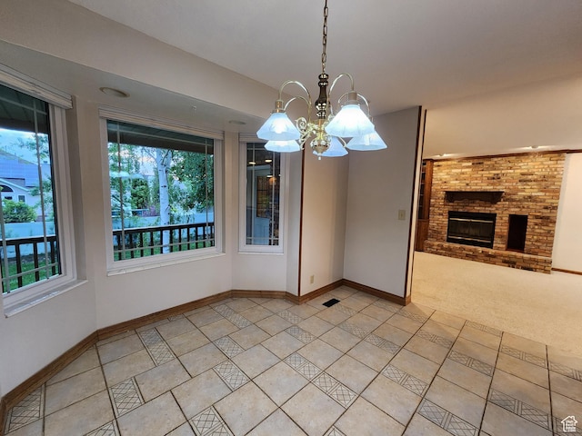 unfurnished dining area featuring plenty of natural light, a fireplace, baseboards, and a chandelier
