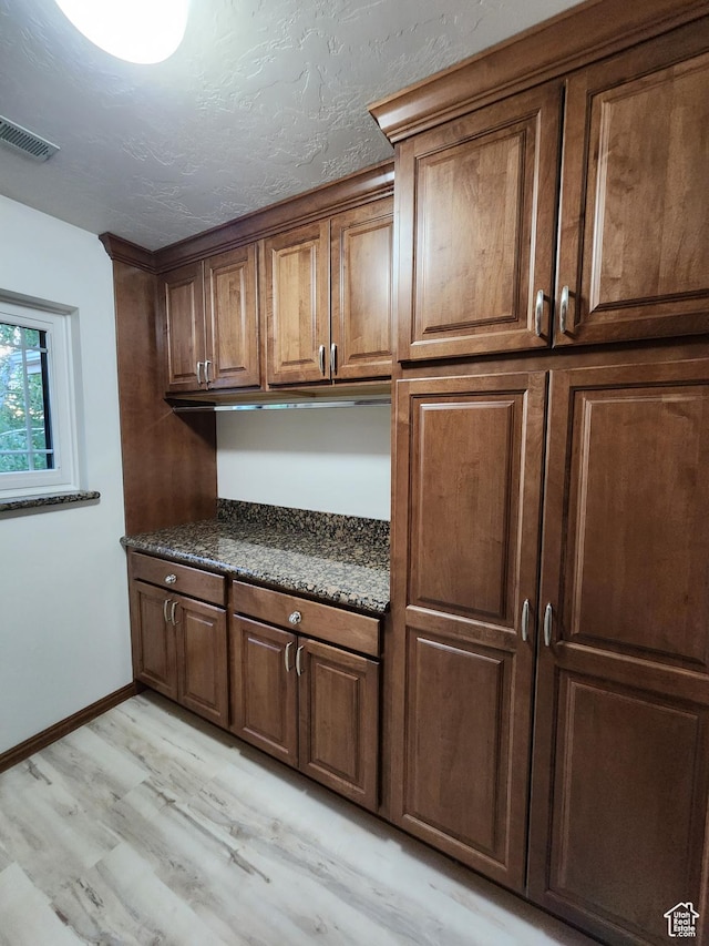 kitchen with dark countertops, light wood-style floors, and baseboards