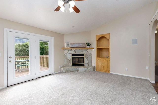 540 N 100 E, Hyde Park, UT 84318 - unfurnished living room with a ceiling fan, arched walkways, baseboards, a stone fireplace, and carpet flooring