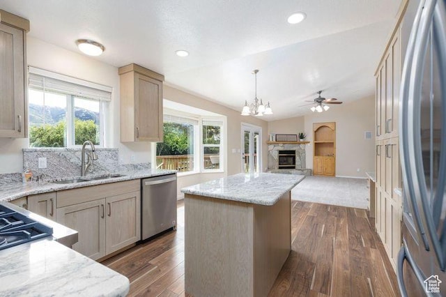 540 N 100 E, Hyde Park, UT 84318 - kitchen with appliances with stainless steel finishes, a sink, open floor plan, a stone fireplace, and dark wood-type flooring