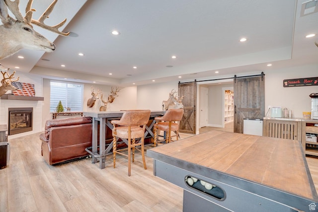 2700 E Red Barn Rd S, Heber City, UT 84032 - dining area with a barn door, a tray ceiling, light wood-type flooring, recessed lighting, and a fireplace