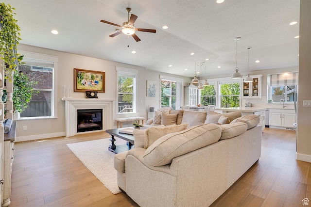 2700 E Red Barn Rd S, Heber City, UT 84032 - living room featuring recessed lighting, light wood-type flooring, healthy amount of natural light, a ceiling fan, and a glass covered fireplace