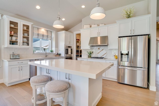 2700 E Red Barn Rd S, Heber City, UT 84032 - kitchen with appliances with stainless steel finishes, under cabinet range hood, a kitchen island, light wood finished floors, and white cabinetry