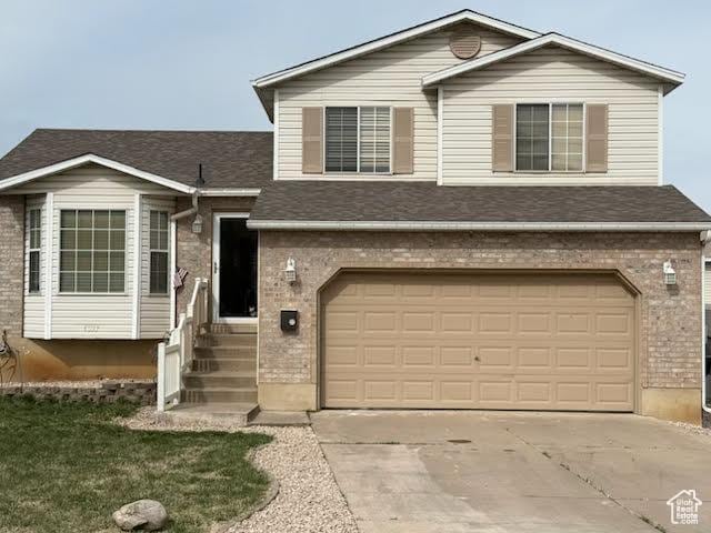4327 S Westlake W, Roy, UT 84067 - view of front of property featuring an attached garage, brick siding, and concrete driveway