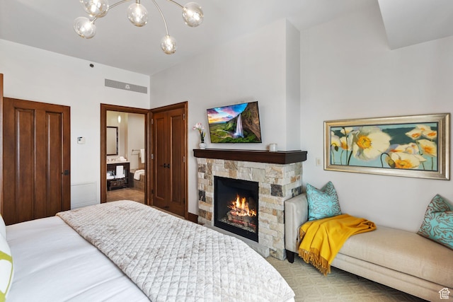 bedroom with a chandelier and a stone fireplace