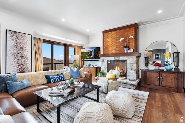 living room with crown molding, wood finished floors, a fireplace, and recessed lighting