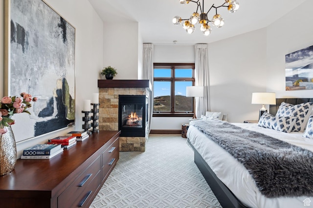 bedroom with a stone fireplace and a chandelier