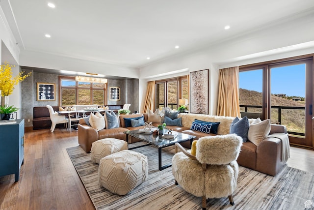 living room featuring recessed lighting, light wood finished floors, and ornamental molding