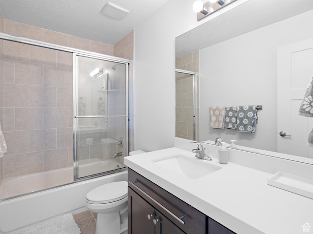 full bathroom with toilet, shower / bath combination with glass door, vanity, tile patterned flooring, and a textured ceiling