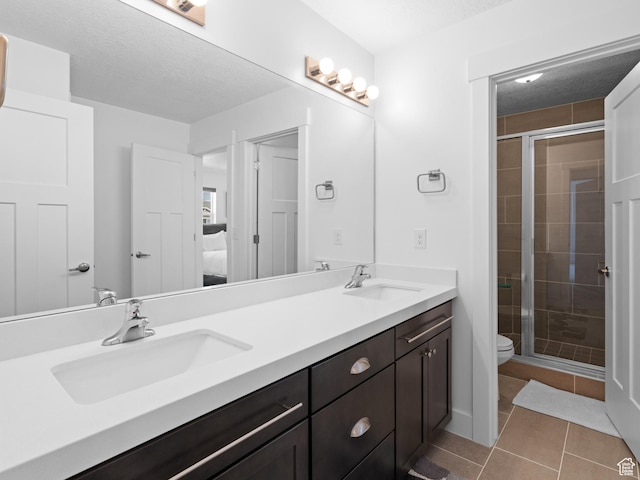 bathroom featuring a stall shower, double vanity, connected bathroom, and tile patterned flooring