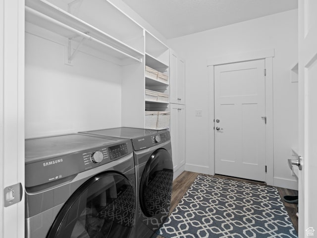 laundry area featuring washing machine and clothes dryer, wood finished floors, and baseboards