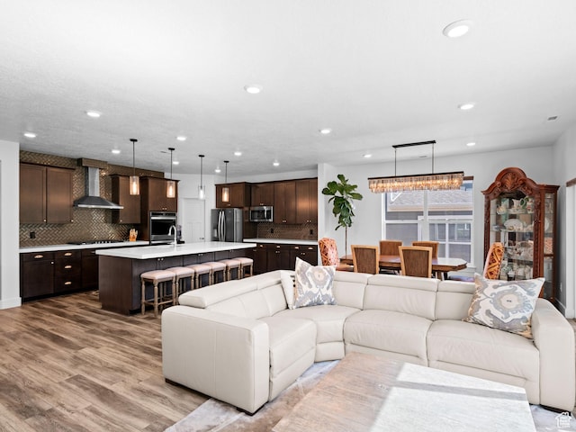 living area featuring light wood-type flooring and recessed lighting