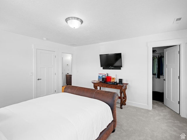 bedroom with light colored carpet, a spacious closet, a closet, and baseboards