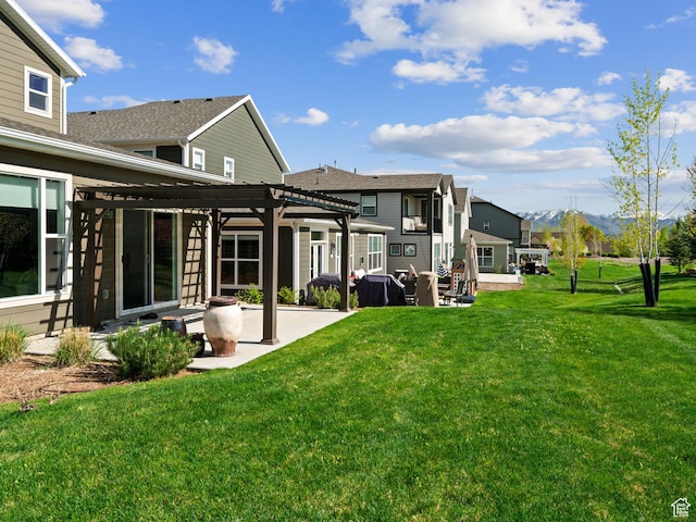 rear view of property with a pergola, a patio, a mountain view, and a yard