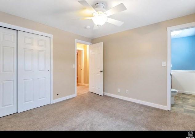 unfurnished bedroom with carpet floors, baseboards, a closet, and a ceiling fan